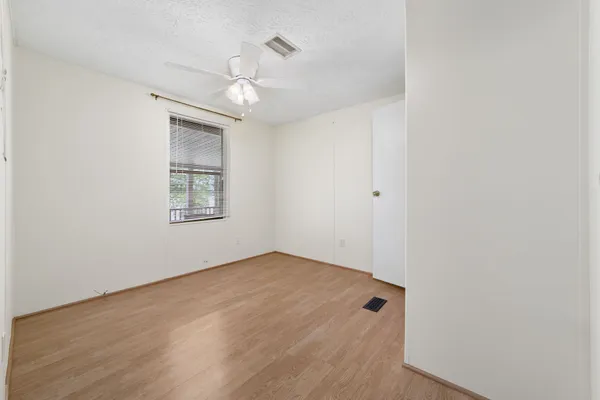 a view of an empty room with wooden floor and entryway