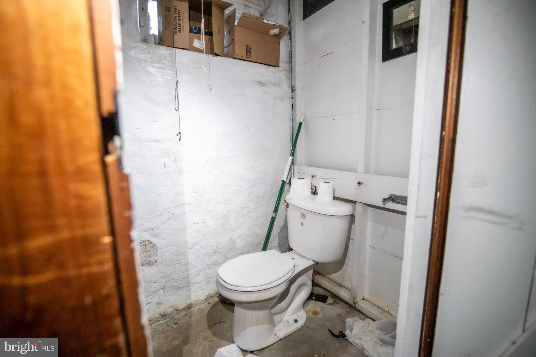 1649 Ralworth Road Baltimore, MD 21218 - Photo 27 of 47 a white toilet sitting next to a shower curtain