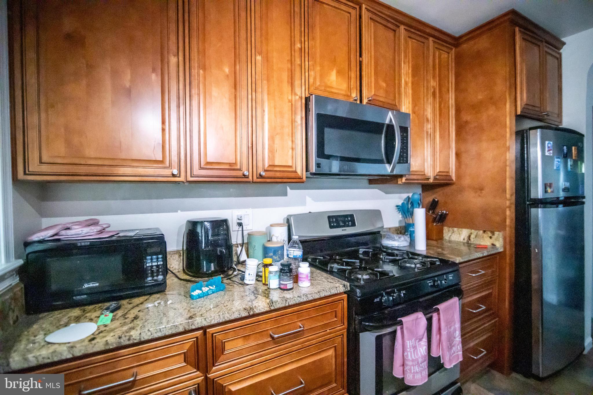 1649 Ralworth Road Baltimore, MD 21218 - Photo 40 of 47 a kitchen with stainless steel appliances granite countertop a stove a sink and a microwave