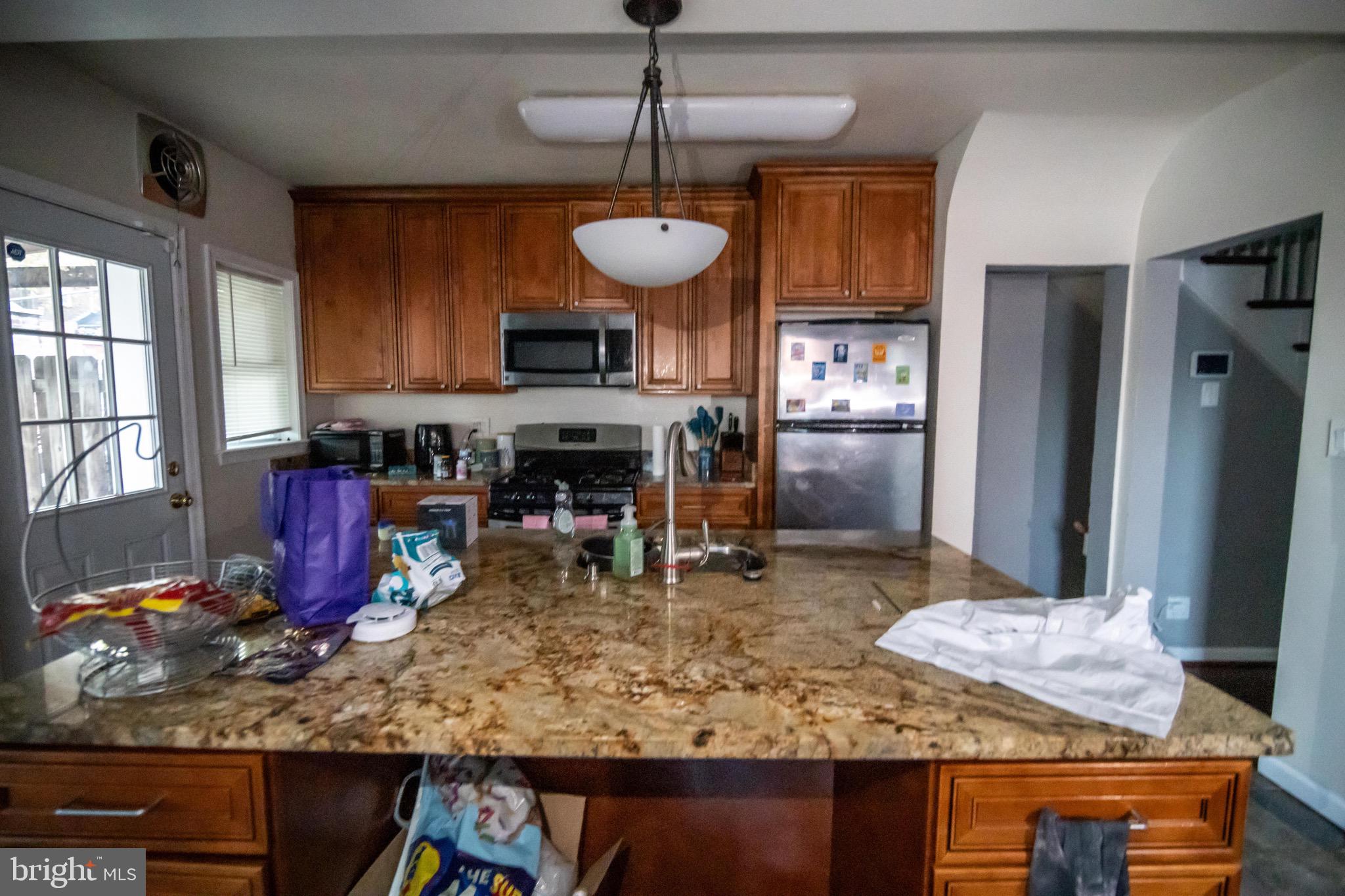 1649 Ralworth Road Baltimore, MD 21218 - Photo 42 of 47 a kitchen with kitchen island granite countertop a stove refrigerator and cabinets