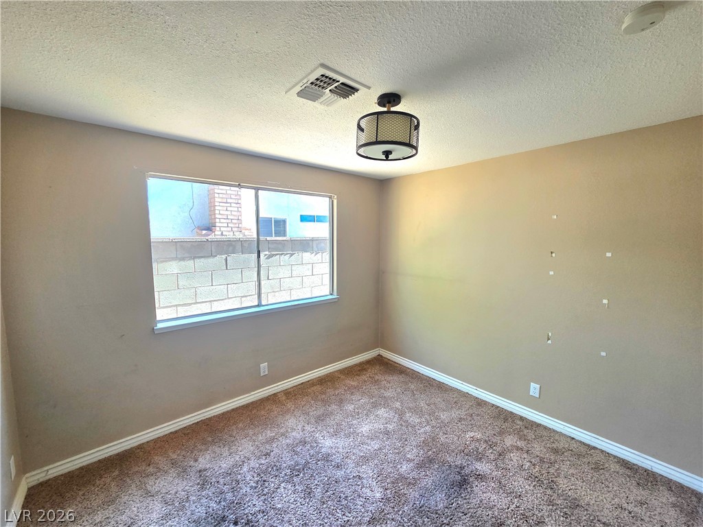 3648 Bronco Road Las Vegas, NV 89103 - Photo 11 of 24 A well-lit bedroom with soft carpet offers a comforting retreat.