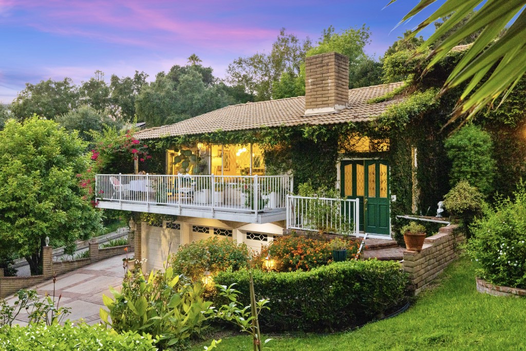 a backyard of a house with table chairs and a small yard