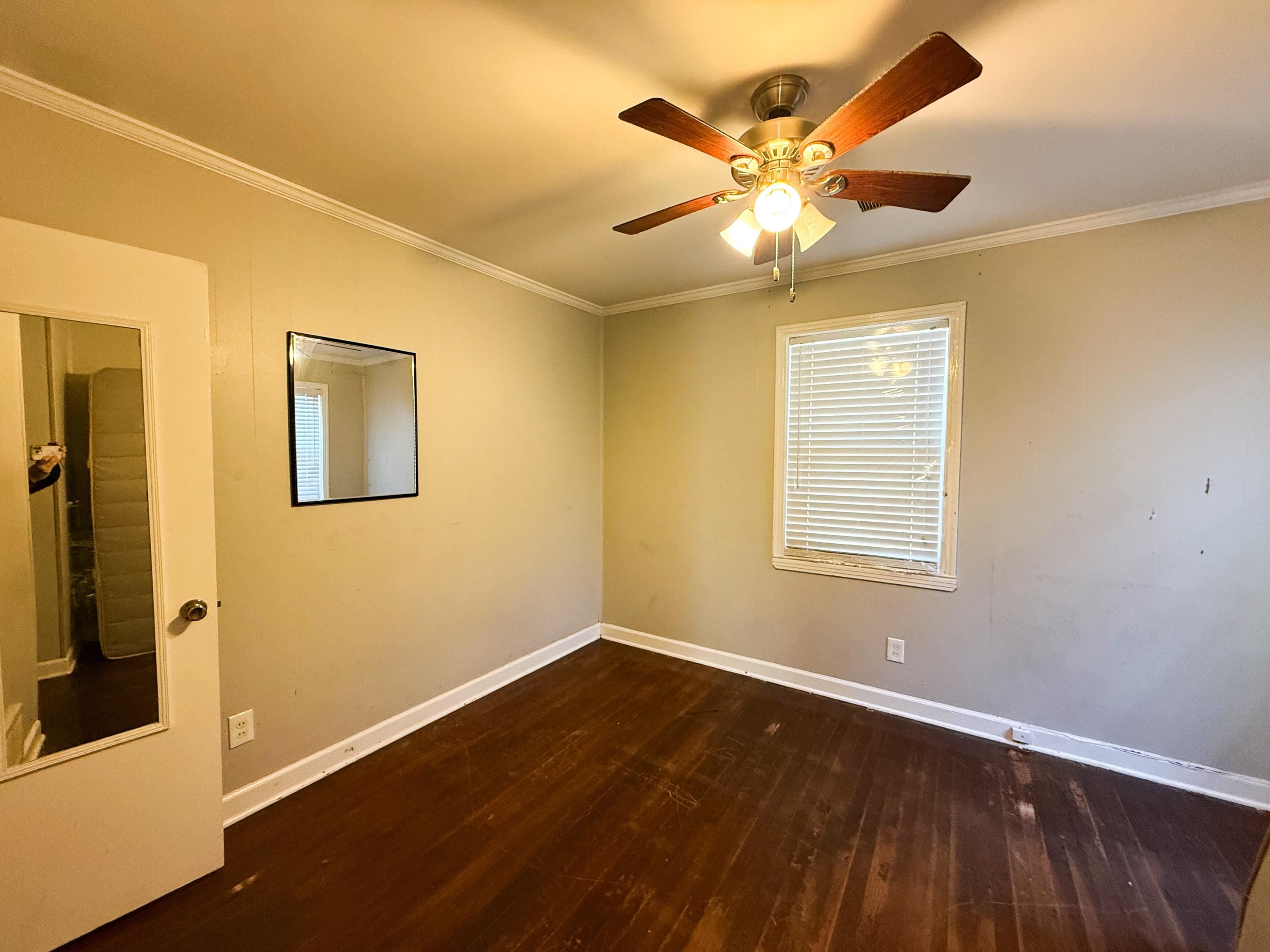1027 Waring Road Memphis, TN 38122 - Photo 14 of 14 Empty room with dark wood-style flooring, ornamental molding, and a ceiling fan