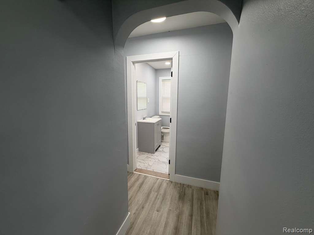 7416 Heyden Detroit, MI 48228 - Photo 12 of 16 Corridor featuring light wood finished floors and arched walkways