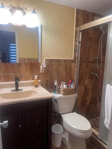 a bathroom with a sink toilet and shower