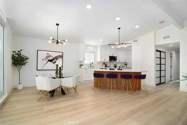 a living room with furniture kitchen view and a chandelier