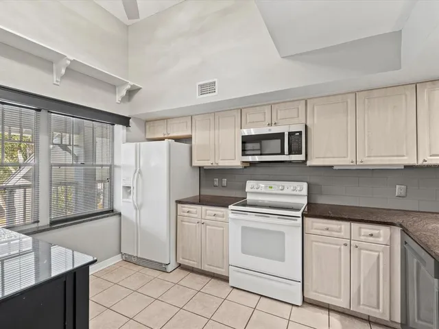 a kitchen with white cabinets and white appliances