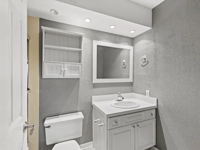 a bathroom with a toilet a sink and mirror