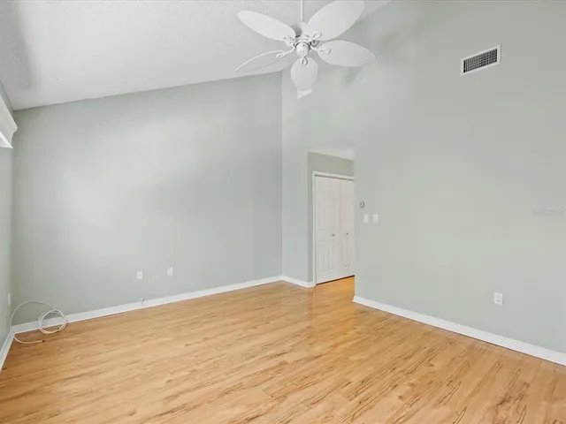 a view of empty room with wooden floor