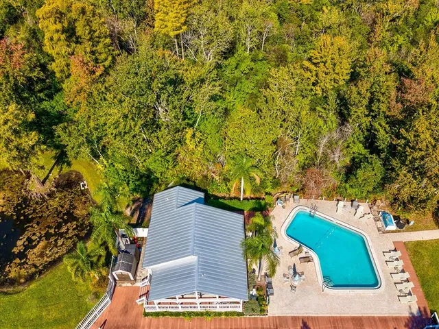 an aerial view of a house with swimming pool and outdoor seating
