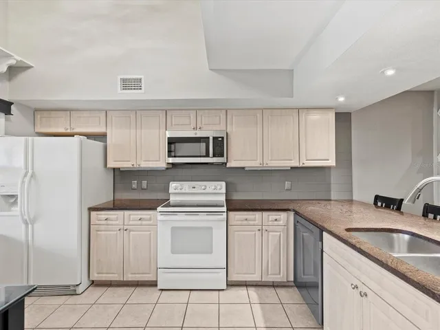 a kitchen with white cabinets sink and white appliances