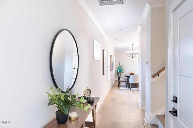 a view of a hallway with wooden floor and a potted plant