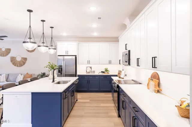 a large kitchen with kitchen island a stove a sink a center island and furniture