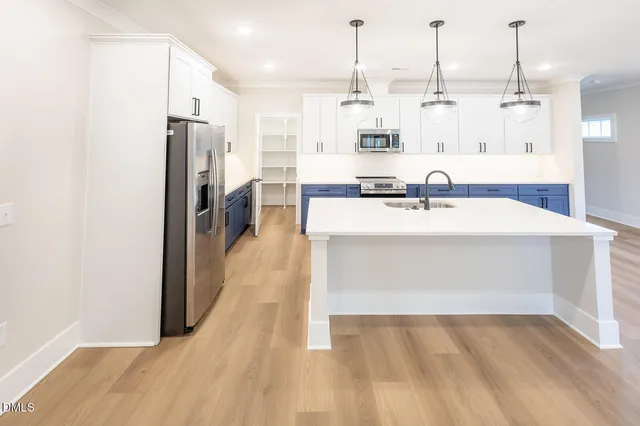 a view of a kitchen with kitchen island a sink wooden floor and living room view