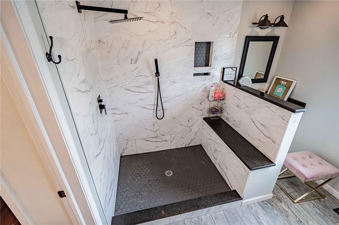 102 Sutton Road Easton, PA 18045 - Photo 42 of 83 Elegant marble-patterned tile walls and a built-in bench highlight this modern walk-in shower.