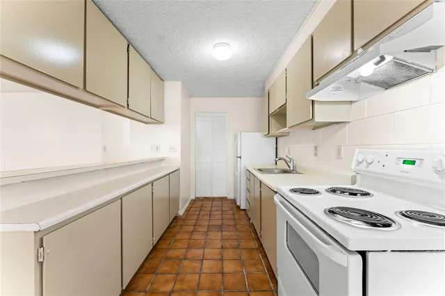 a kitchen with a stove and a white refrigerator