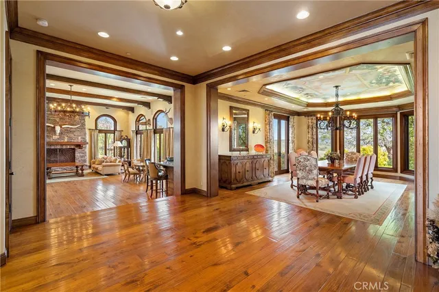a dining room with furniture a chandelier and wooden floor