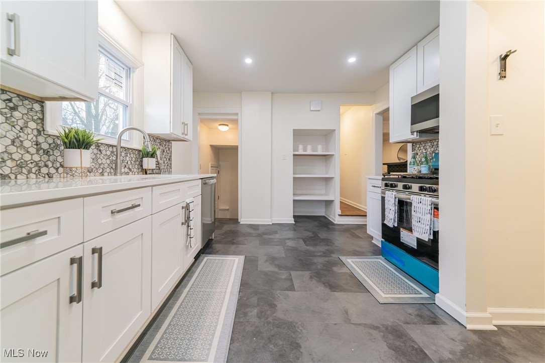 1391 Avondale Road Cleveland, OH 44121 - Photo 16 of 46 Kitchen featuring white cabinetry, tasteful backsplash, stainless steel appliances, baseboards, and recessed lighting
