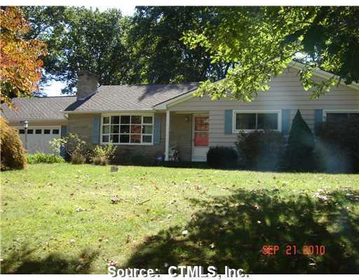 a backyard of a house with wooden fence and large tree