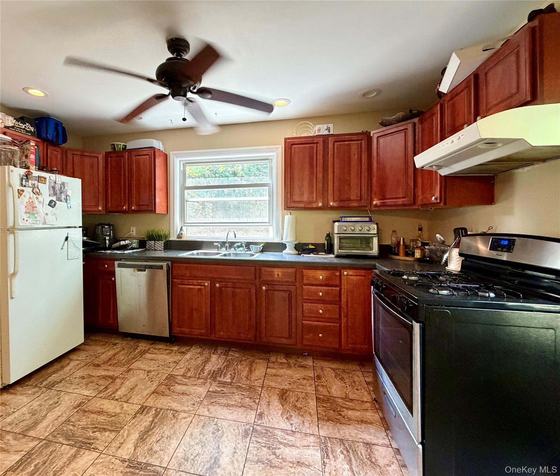 149 Fort Salonga Road Northport, NY 11768 - Photo 20 of 23 Kitchen featuring wood cabinetry, dark countertops, and tile flooring