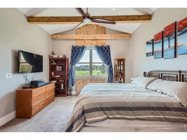 a bedroom with a bed and a flat tv screen on dresser