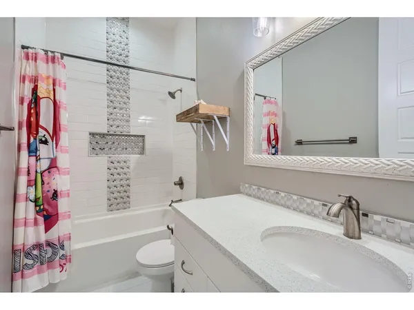 a bathroom with a sink vanity granite and a shower