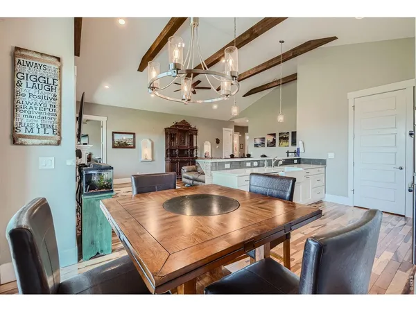 a room with stainless steel appliances kitchen island a table chairs and a chandelier