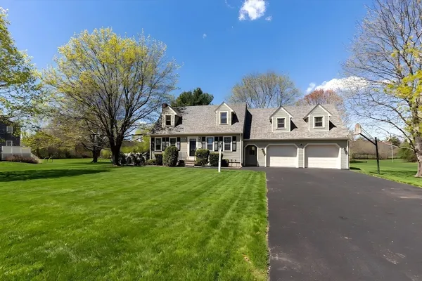 a view of a big house with a big yard and large tree