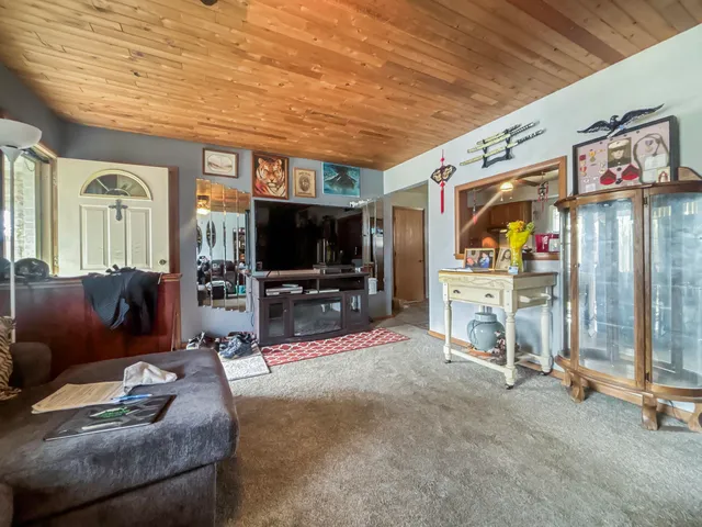 a kitchen with stainless steel appliances granite countertop a sink dishwasher a dining table and chairs with wooden floor