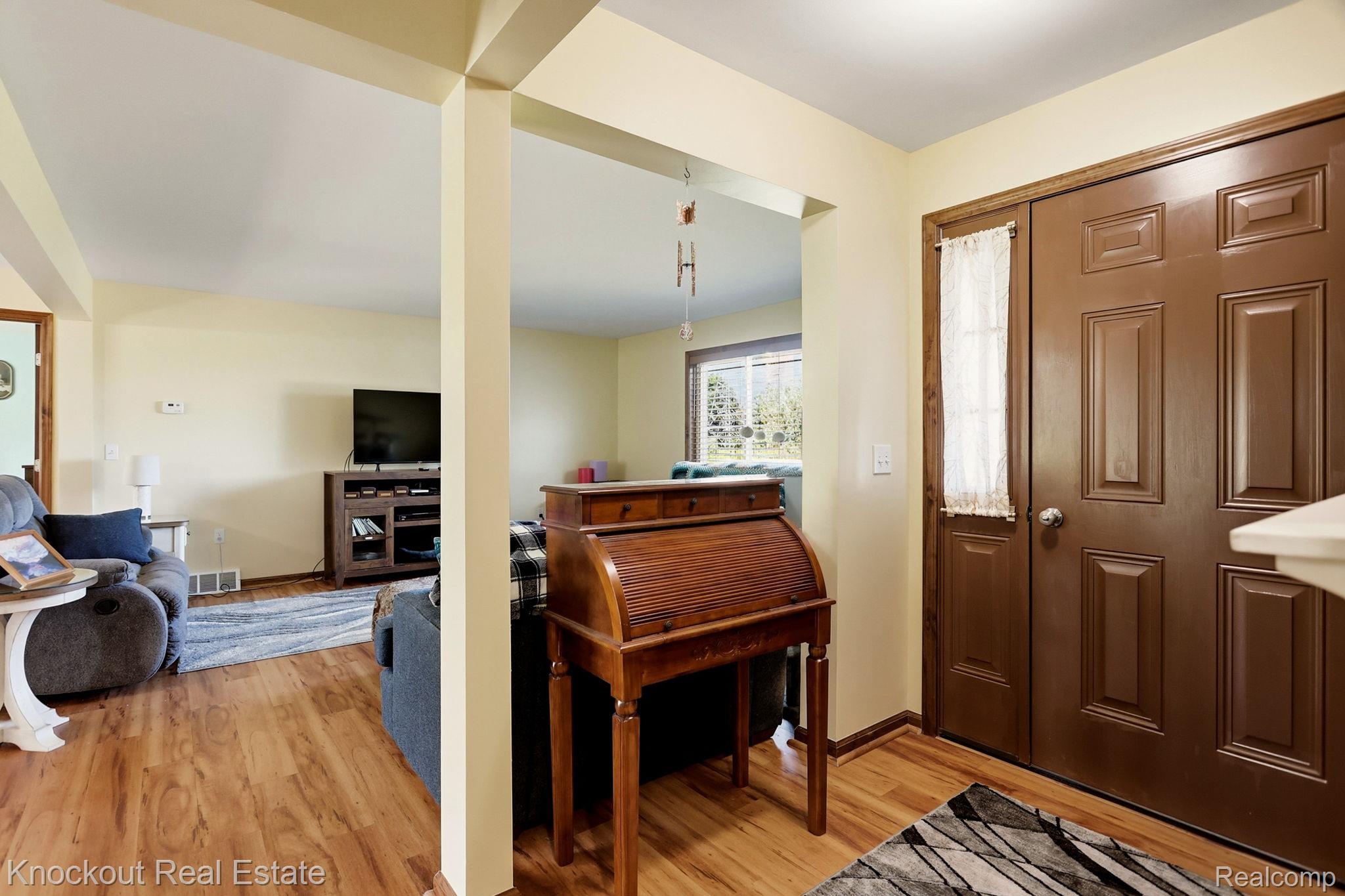 5727 Mackinaw Road Saginaw, MI 48604 - Photo 9 of 60 Warm wood-finish flooring throughout, featuring a functional closet with paneled double doors and a transom window accent, illuminated by recessed lighting