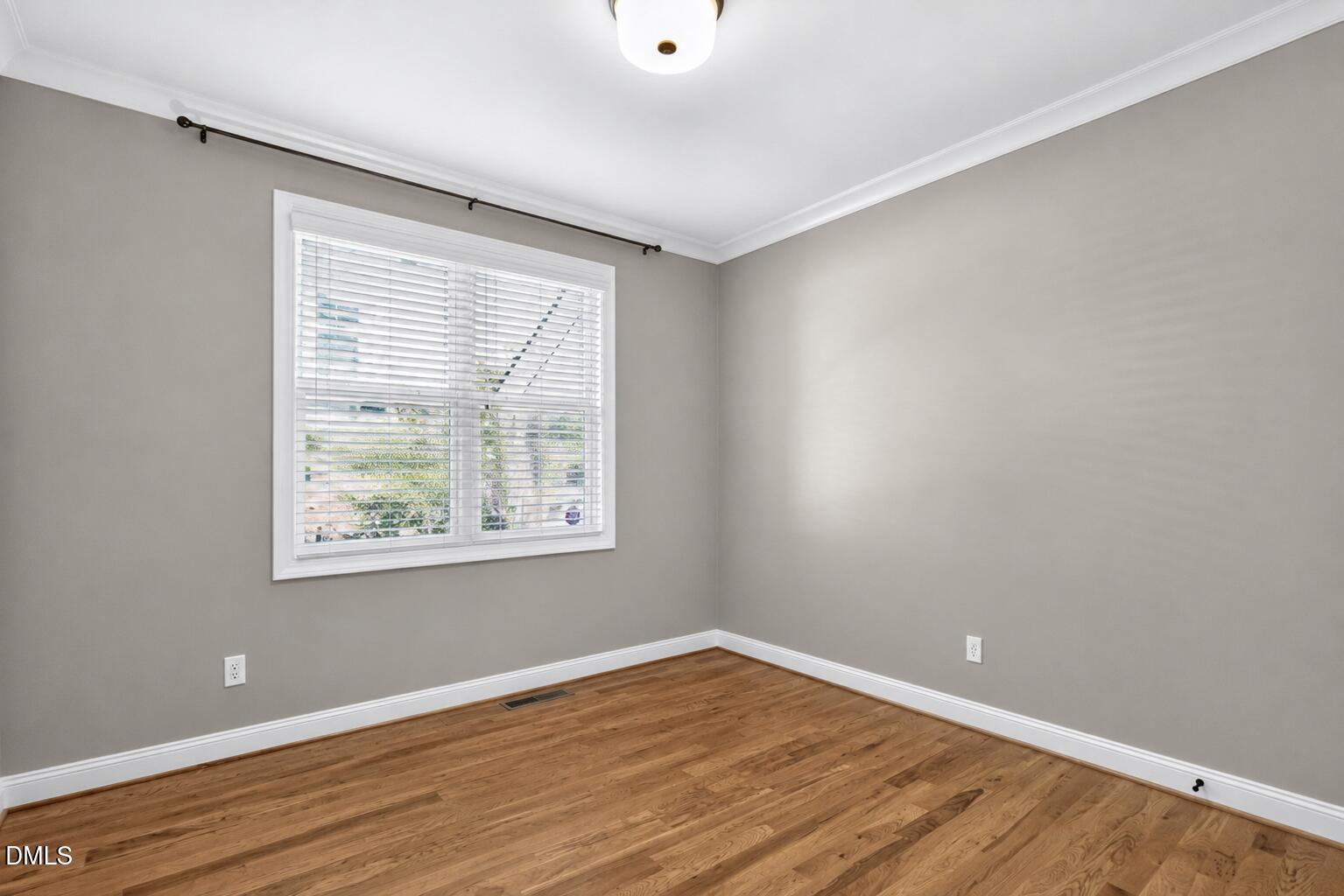 2745 Oberlin Road, Unit 103 Raleigh, NC 27608 - Photo 16 of 23 a view of an empty room with wooden floor and a window