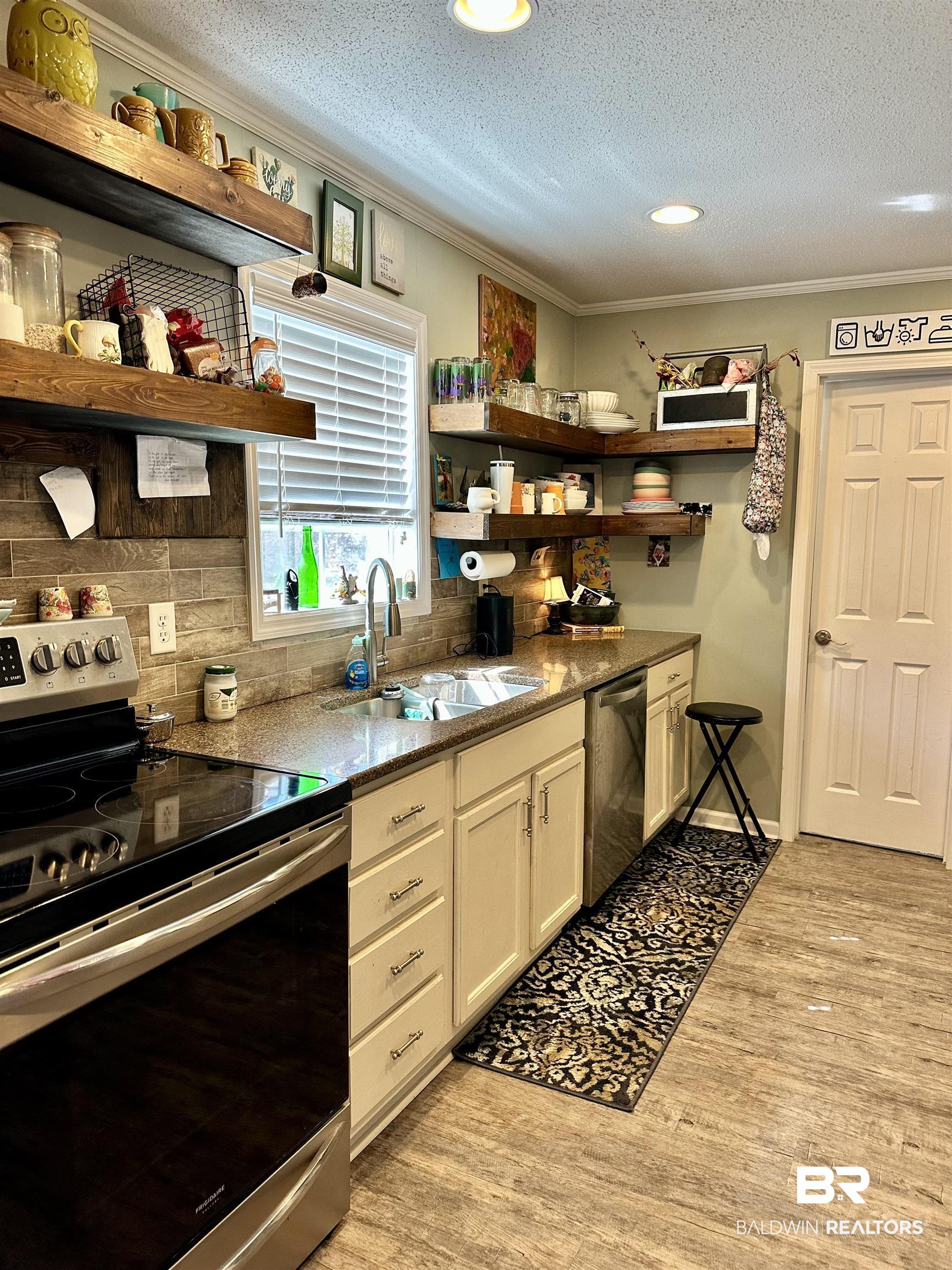 120 McGougin Road Brewton, AL 36426 - Photo 7 of 21 Kitchen with appliances with stainless steel finishes, open shelves, a sink, and ornamental molding