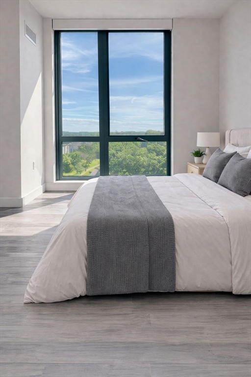 80 Fenwood Road, Unit 706 Boston, MA 02115 - Photo 6 of 33 a bedroom with a bed lamp and a large window