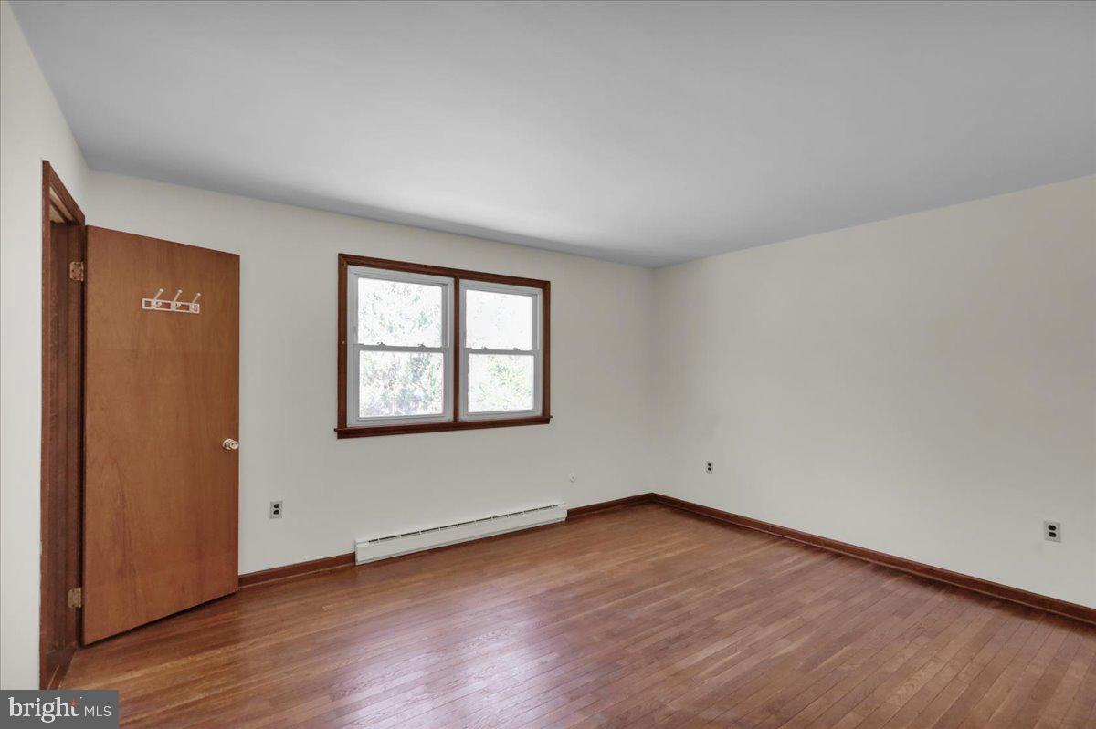 982 Fairview Road Glenmoore, PA 19343 - Photo 26 of 74 an empty room with wooden floor and windows