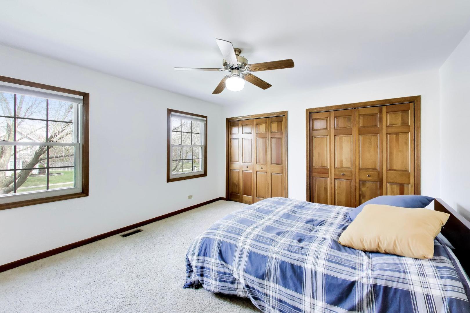 1528 Sequoia Road Naperville, IL 60540 - Photo 19 of 34 a bedroom with a bed next to a window with a chandelier