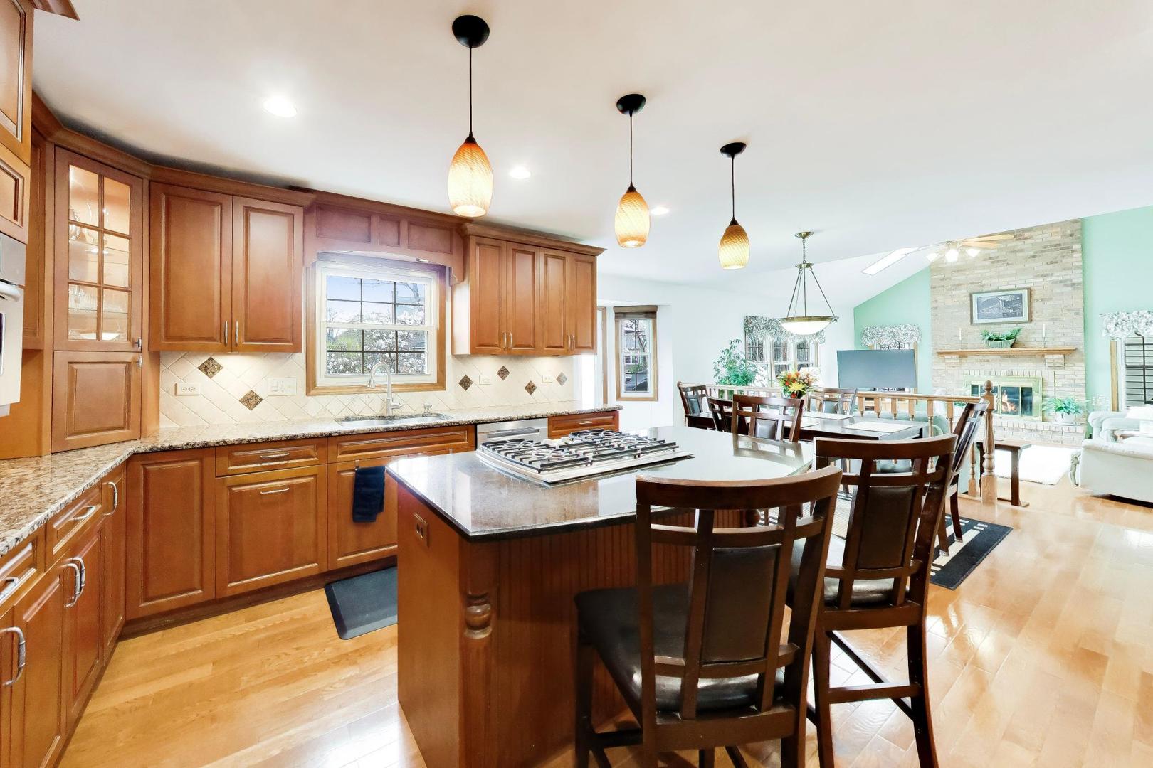 1528 Sequoia Road Naperville, IL 60540 - Photo 10 of 34 a kitchen with a dining table chairs sink and cabinets