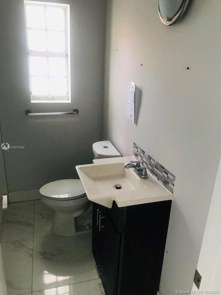 770 Northeast 77th Street Miami, FL 33138 - Photo 14 of 20 a sink and a toilet sitting in a bathroom