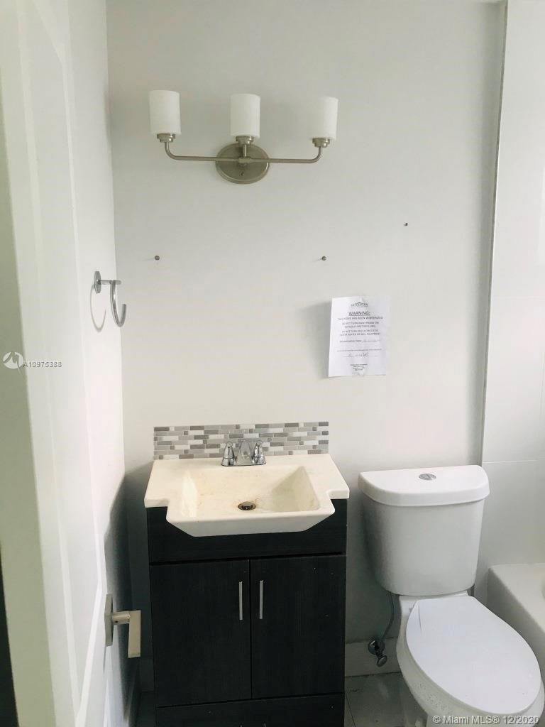 770 Northeast 77th Street Miami, FL 33138 - Photo 17 of 20 a bathroom with a sink a toilet and a mirror