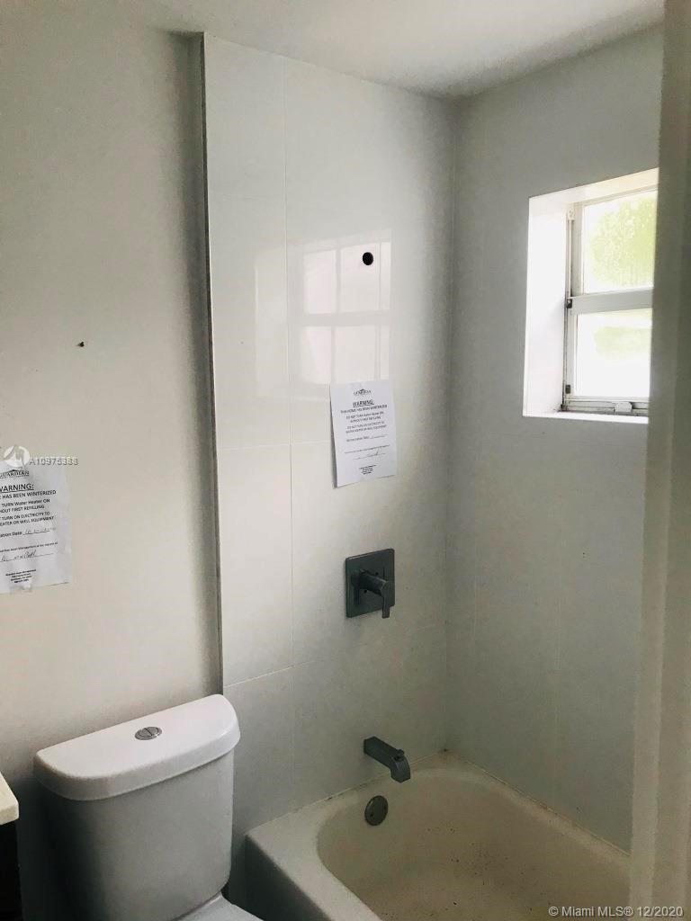 770 Northeast 77th Street Miami, FL 33138 - Photo 18 of 20 a white toilet sitting next to a bath tub