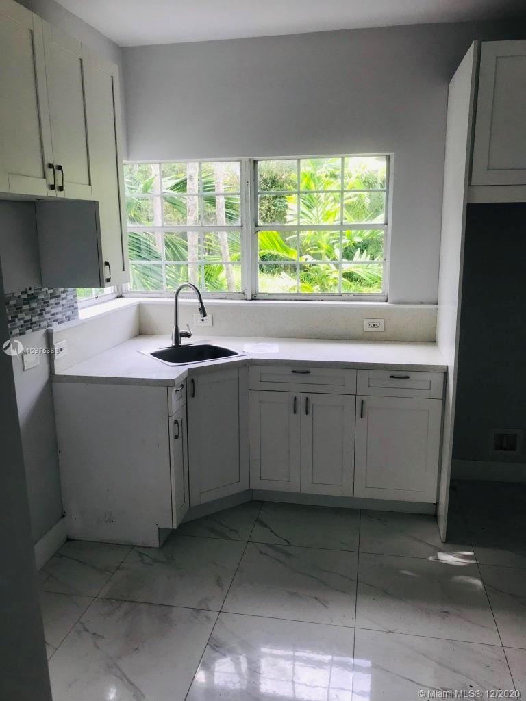 770 Northeast 77th Street Miami, FL 33138 - Photo 10 of 20 a kitchen with a sink window and cabinets