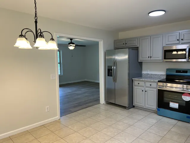 a kitchen with stainless steel appliances granite countertop a refrigerator a stove and a sink