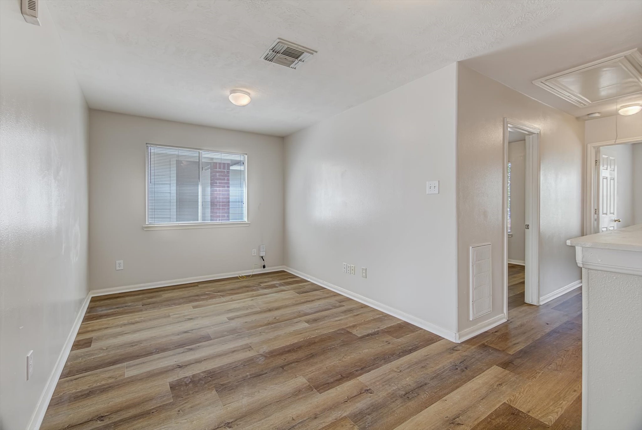 13983 Maximos Drive Houston, TX 77083 - Photo 14 of 34 a view of an empty room with wooden floor and a window