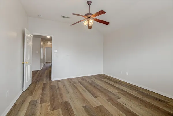 a view of empty room with wooden floor