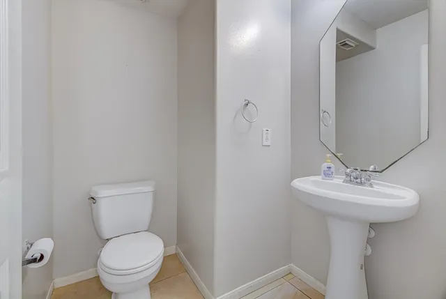 a bathroom with a sink toilet and a mirror