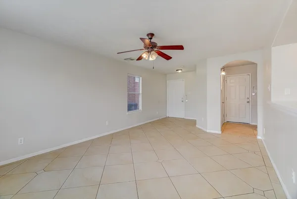 a view of a livingroom with a chandelier fan and windows