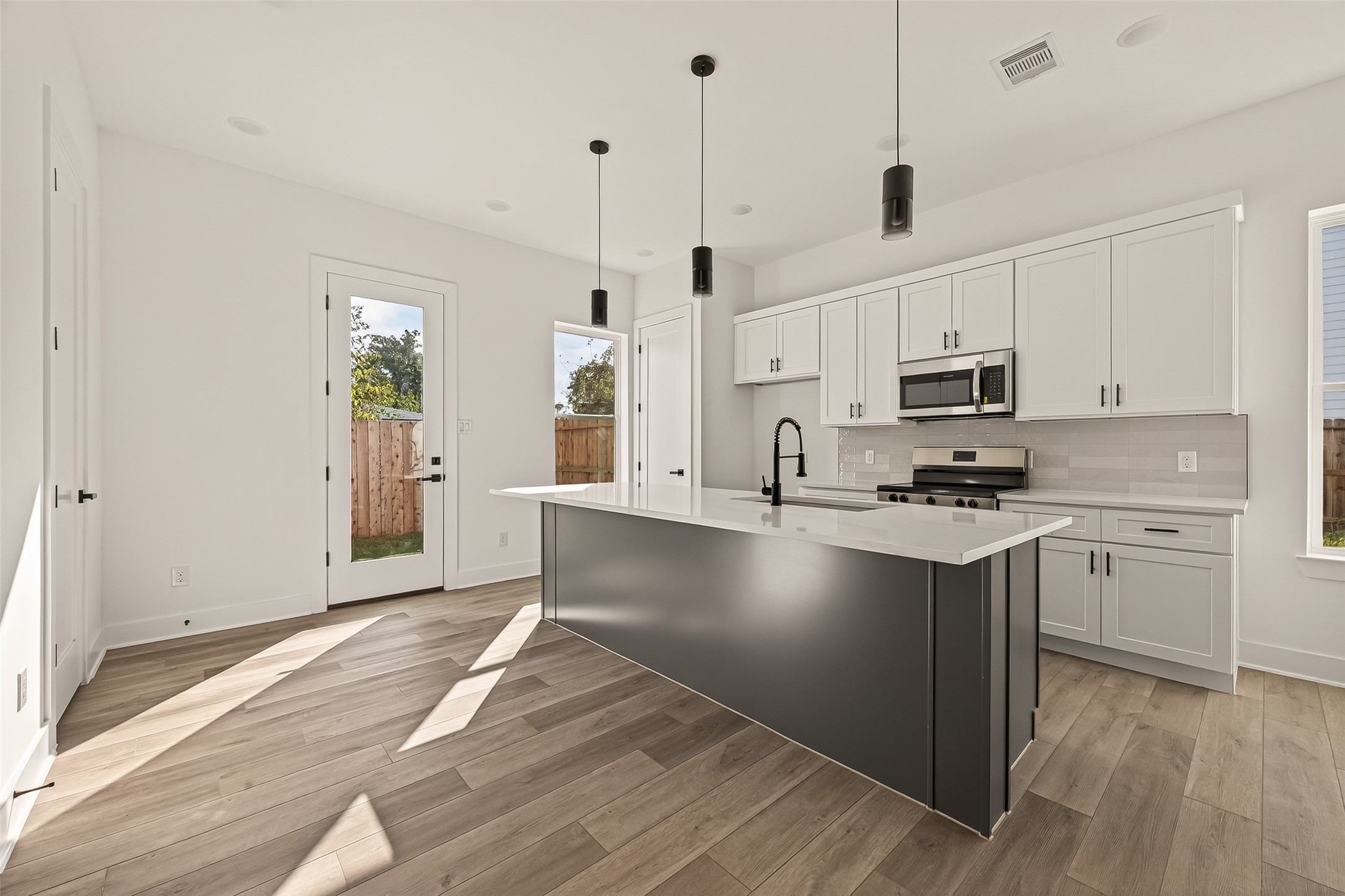 2475 Carmel Street, Unit B Houston, TX 77091 - Photo 1 of 21 Sleek kitchen with quartz countertops, large island, and stainless steel appliances.