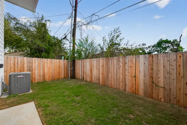 a view of a backyard with potted plants and wooden fence