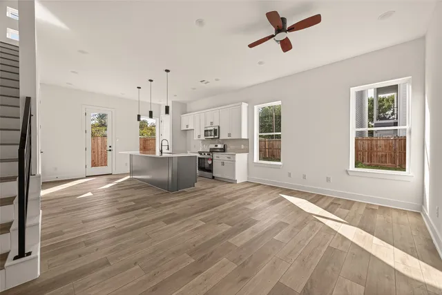 a view of a kitchen with wooden floor and windows