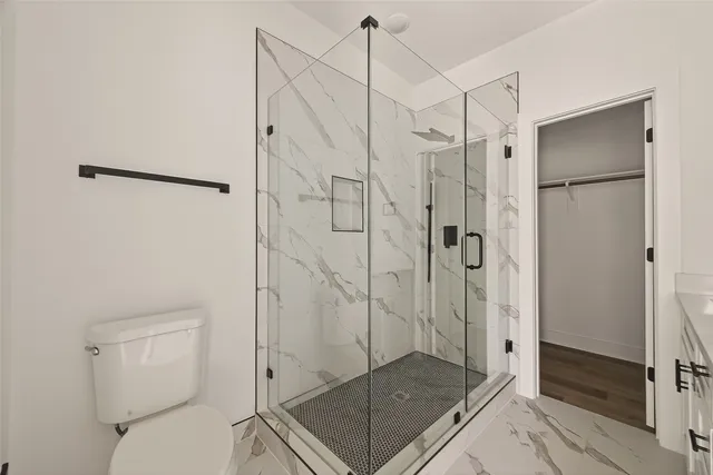 a bathroom with a shower toilet and sink