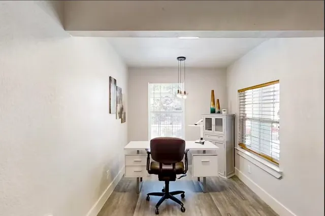 a view of a workspace with furniture and a window